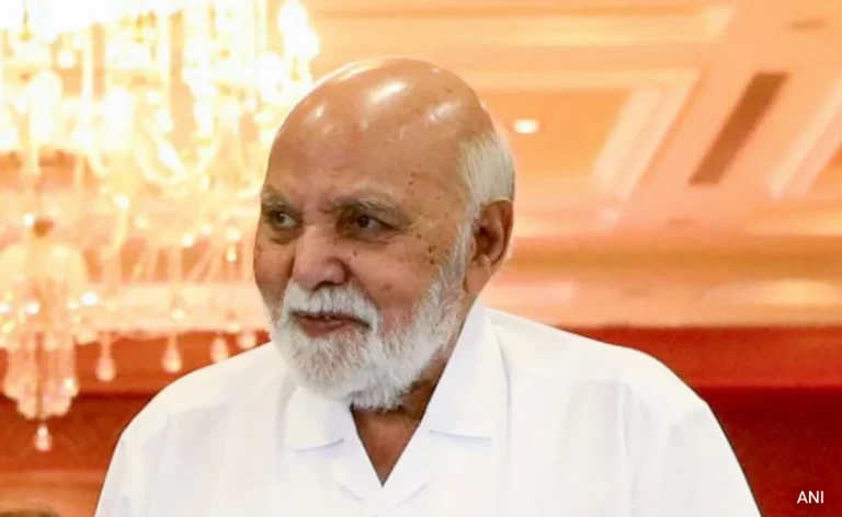Black and white portrait of Ramji Rao, an Indian man with a kind smile and short dark hair, wearing a suit and tie.